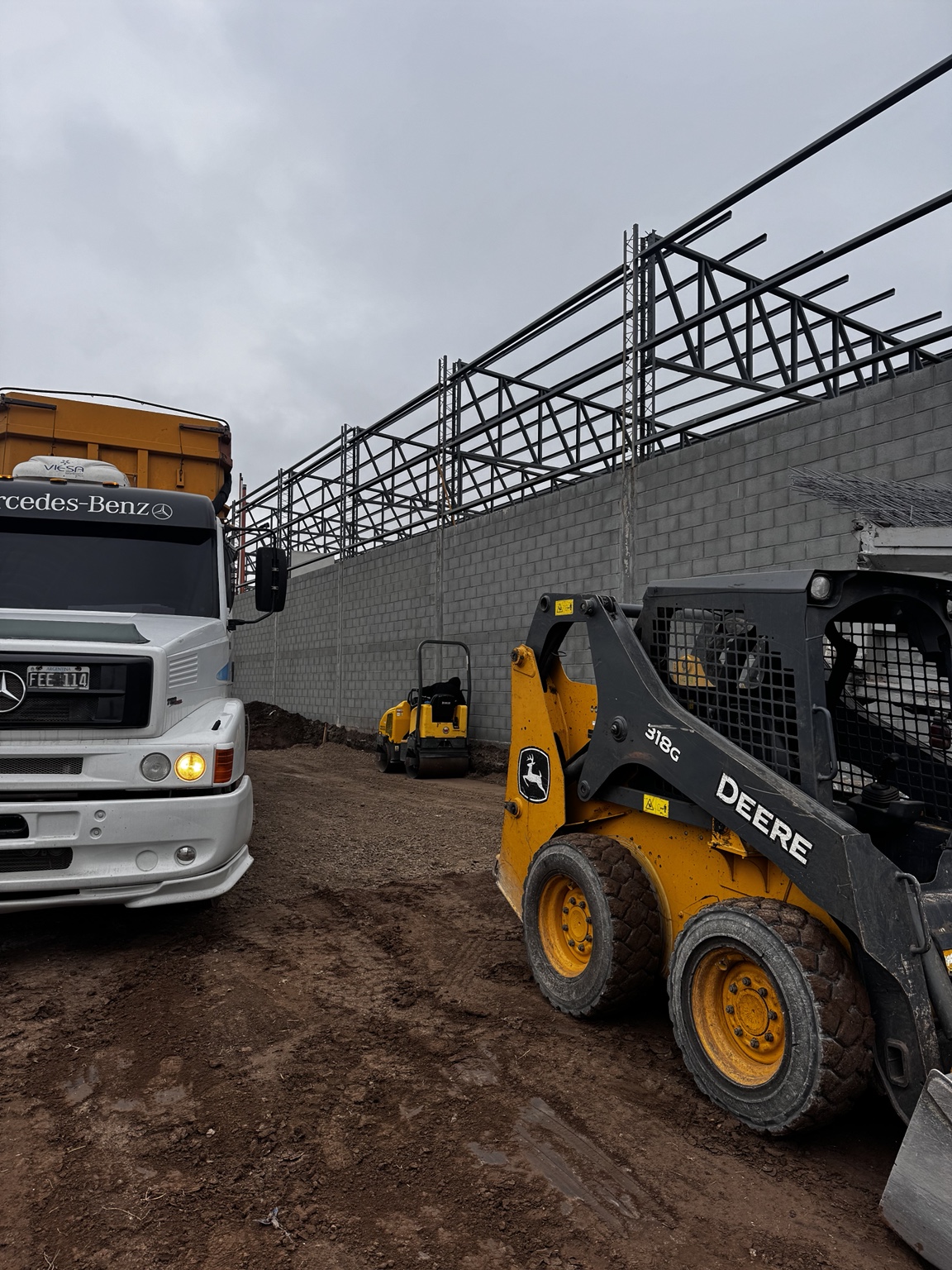 Minicargadora John Deere y camión en una obra de Filardi MS